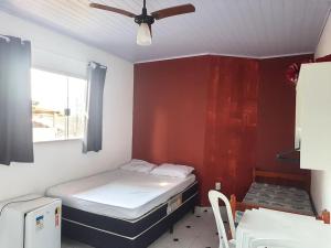 a bedroom with a bed and a ceiling fan at Suites do Rafa Ubatuba in Ubatuba