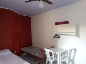 a room with a table and chairs and a bed at Suites do Rafa Ubatuba in Ubatuba