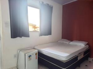 a small room with two beds and a window at Suites do Rafa Ubatuba in Ubatuba