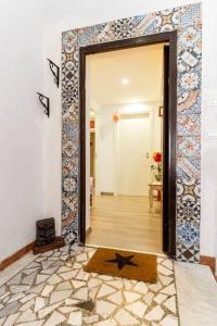 a hallway with a door open to a room with a tile wall at GuestHouse Pet's Friendly in Quattromiglia