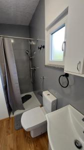 een badkamer met een douche, een toilet en een wastafel bij Unatime.Krupa in Bosanska Krupa