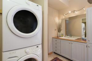 a washer and dryer in a bathroom with a sink at 383 County Road 508 by Stay Winter Park in Fraser