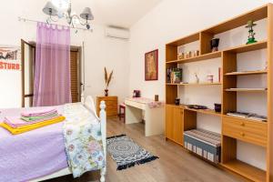 a bedroom with a bed and a desk and shelves at GuestHouse Pet's Friendly in Quattromiglia