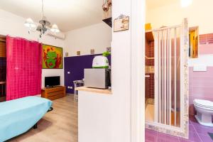 Habitación con paredes rosas y moradas y baño. en GuestHouse Pet's Friendly, en Quattromiglio