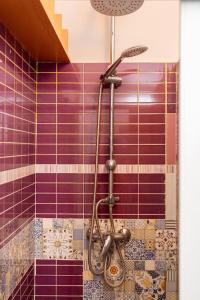 y baño con ducha y azulejos morados. en GuestHouse Pet's Friendly, en Quattromiglio