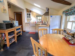 uma cozinha com uma mesa de madeira e um frigorífico em Beckside Studio em Patterdale