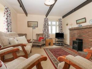 a living room filled with furniture and a fireplace at Parc An Castle Cottage in Lizard