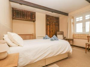 a bedroom with a large white bed and a window at Parc An Castle Cottage in Lizard
