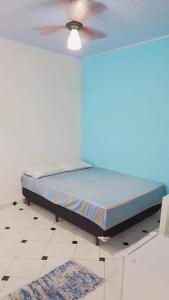 a bed in a room with a ceiling fan at Suites do Rafa Ubatuba in Ubatuba