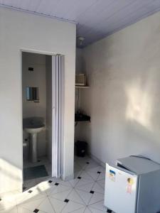 a bathroom with a refrigerator and a sink at Suites do Rafa Ubatuba in Ubatuba