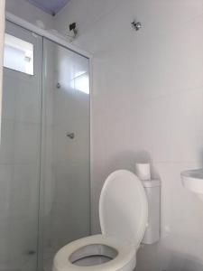 a white bathroom with a toilet and a shower at Suites do Rafa Ubatuba in Ubatuba