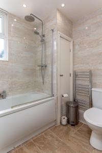 ein Badezimmer mit einer Dusche, einer Badewanne und einem WC in der Unterkunft Air Host and Stay - Spacious 5-Bed Retreat in Edge Grove Sleeps 9 in Liverpool