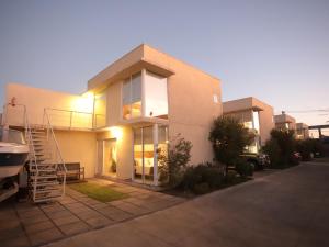 a white house with a staircase in front of it at De Triana Hotel in Rancagua