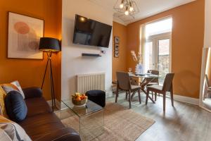 a living room with a couch and a table at Air Host and Stay - Spacious 5-Bed Retreat in Edge Grove Sleeps 9 in Liverpool