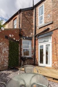 a brick building with a table in front of it at Air Host and Stay - Spacious 5-Bed Retreat in Edge Grove Sleeps 9 in Liverpool