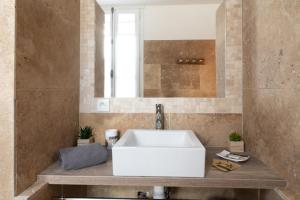 ein Badezimmer mit einem weißen Waschbecken und einem Spiegel in der Unterkunft Bien d'exception en face du Palais des Papes in Avignon + 43 Fotos