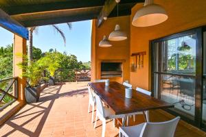 eine Terrasse mit einem Holztisch und Stühlen auf dem Balkon in der Unterkunft San Lameer Villa 1925 by Top Destinations Rentals in Southbroom