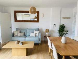 a living room with a blue couch and a table at Saona Coast - Apartamento reformado en playa Arenal, Jávea in Jávea