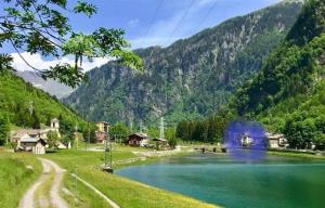 a lake in the middle of a valley with mountains at Mansarda Vista lago a Campodolcino in Campodolcino