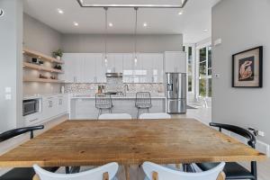 a kitchen with a wooden table and chairs at Luxury Home with Amazing Lake Okanagan Views in Kelowna