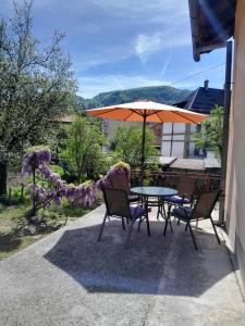 a table and chairs with an umbrella on a patio at Lana apartman Pijavice in Jajce