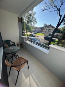 einen Balkon mit einem Tisch und Stühlen sowie einem Fenster in der Unterkunft Apartment Amra in Visoko
