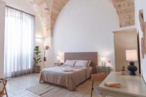 1 dormitorio con cama, mesa y escritorio en Mediterranea Residence, en Nardò