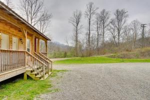 ein Holzhaus mit einer Veranda auf einer Schotterstraße in der Unterkunft Pet-Friendly Briceville Studio with Mountain Views! 