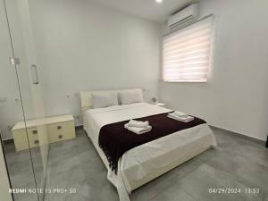 a bedroom with a bed with two towels on it at One bedroom TEA apartment Il-Gzira in Il-Gżira
