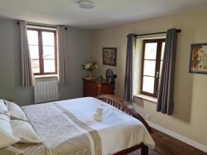 a bedroom with a bed and two windows at La Maison du Lac Lavaud in Saint-Quentin-sur-Charente +37 photos