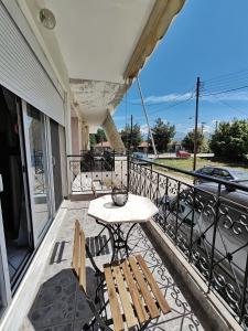 a patio with a table and chairs on a balcony at Ioannina Urban Oasis with Jacuzzi in Katsikás
