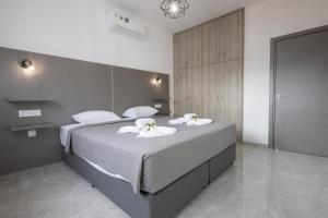 a bedroom with a large bed with towels on it at Bellagio Napa Suites in Ayia Napa