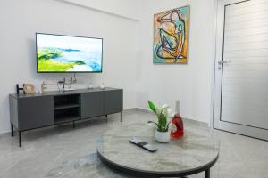 a living room with a tv and a table at Bellagio Napa Suites in Ayia Napa