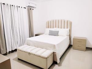 - une chambre avec un grand lit blanc et une chaise dans l'établissement Confortable Apartamento con Piscina en Cabrera, à Cabrera