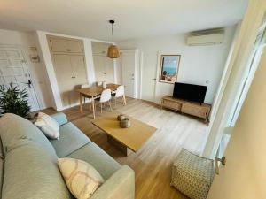 a living room with a couch and a table at Saona Coast - Apartamento reformado en playa Arenal, Jávea in Jávea