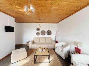 a living room with a couch and a table at Casa do Cacto - 1 Bedroom Flat in Madalena
