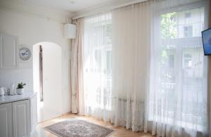 een kamer met een groot raam met witte gordijnen bij Світла затишна квартира в центрі біля Оперного театру з балконом, який виходить у тихий львівський дворик in Lviv