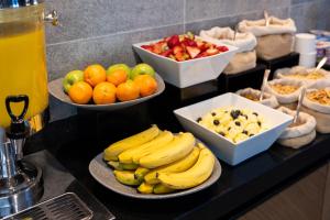 a buffet with bowls of fruit and bowls of oranges and bananas at Holiday Inn Express - Concepcion by IHG in Concepción