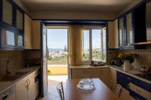 a kitchen with a table and a large window at The Garden House in Aegina Town