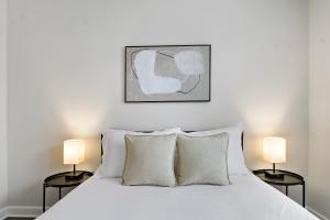 1 dormitorio con 1 cama blanca y 2 lámparas en Well-Equipped 1BR Apt in Hyde Park - Harper 404 en Chicago