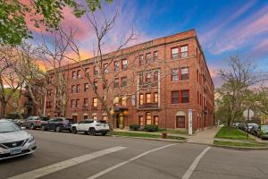 um edifício de tijolos com carros estacionados em frente em Well-Equipped 1BR Apt in Hyde Park - Harper 404 em Chicago