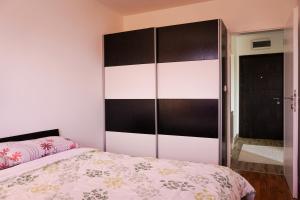 a bedroom with a bed and a large headboard at Good Day- Stan na dan sa garažom in Lukavica