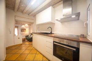 cocina con armarios blancos, fregadero y fogones en Apartamentos Indalo a los pies del Albaicín, en Granada