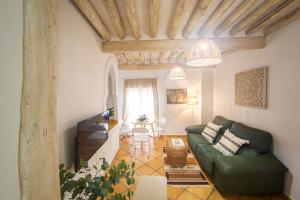 a living room with a green couch and a table at Apartamentos Indalo a los pies del Albaicín in Granada