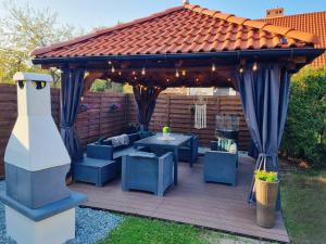 a gazebo with blue chairs and a table at Apartament MASHOUSE Stegna in Stegna