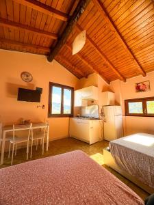 a bedroom with a bed and a table and a kitchen at Casa Vacanze La CASA DEL SOLE in Angolo Terme