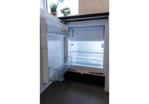 um frigorífico vazio com a porta aberta em Tilburg City, New Rooms And A Kitchen em Tilburg