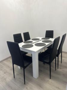 uma mesa branca com quatro cadeiras à volta em Mountain View em Sinaia