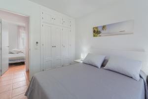 a white bedroom with a bed in a room at Urbanización Jardín del Golf 1 in Novo Sancti Petri