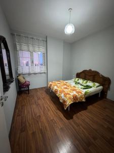 um quarto com uma cama e piso em madeira em SN Apartment city center em Shkodër